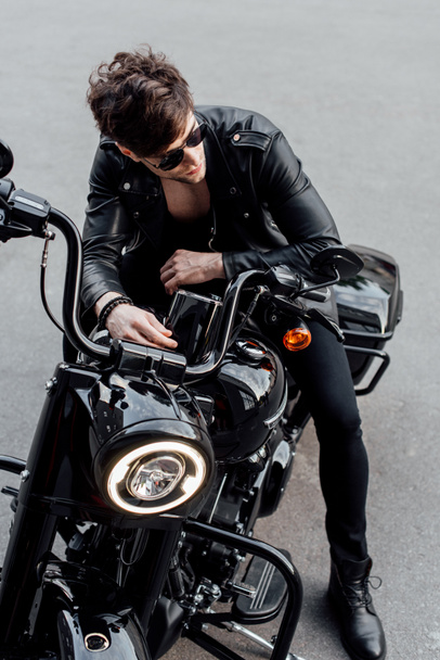 magas látószögű nézet a fiatal férfi bőrdzseki ült a motorkerékpár - Fotó, kép