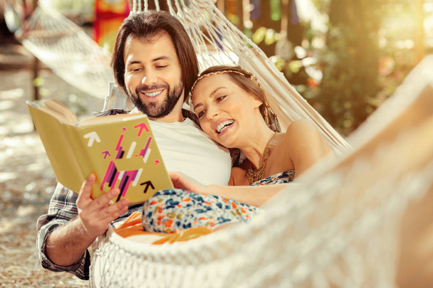 Happy positive couple reading a funny story - Фото, изображение