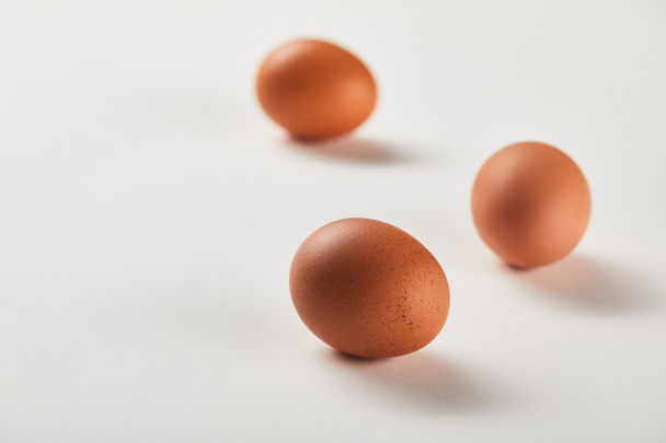 selective focus of chicken eggs on white surface - Fotoğraf, Görsel
