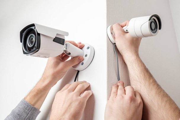 Workers installing video surveillance cameras on walls - Фото, зображення