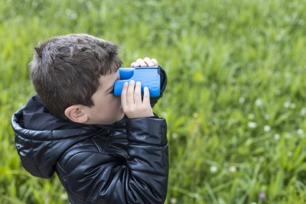 Malé děcko, které se dívá s modrým dalekohledem - Fotografie, Obrázek