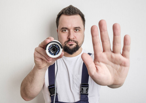 Technician with CCTV security camera showing stop gesture - Φωτογραφία, εικόνα