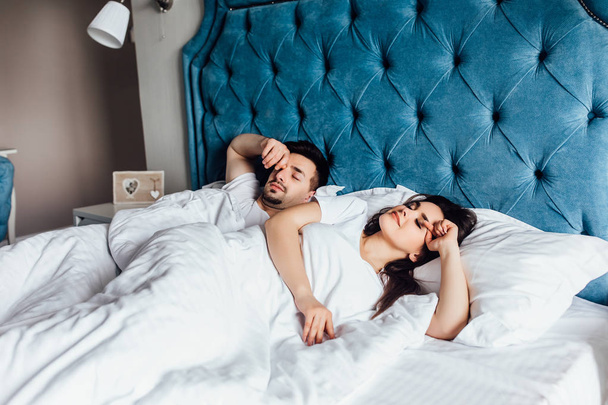 young couple in bed together, focus on foreground - 写真・画像