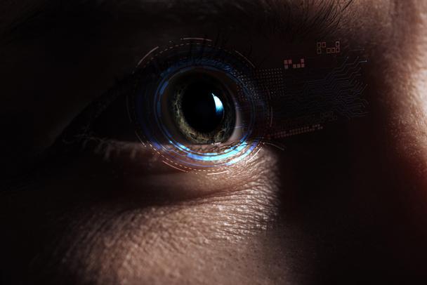 close up view of human eye with data illustration in darkness, robotic concept - Photo, Image