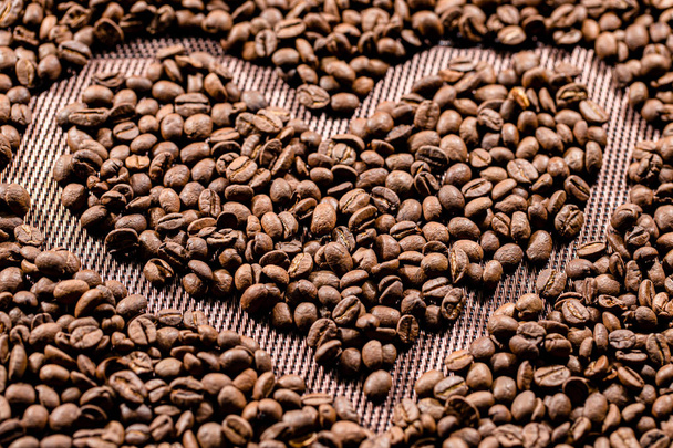 De gebakken koffiebonen liggen in de vorm van een hart. Arabische koffie. - Foto, afbeelding