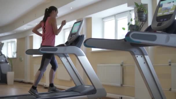 Joven mujer sexy corriendo en una cinta de correr simulador en el pasillo
 - Imágenes, Vídeo