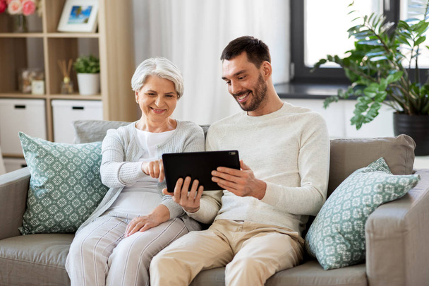 old mother and adult son with tablet pc at home - Valokuva, kuva