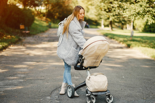 young mother pushing a stroller - Valokuva, kuva