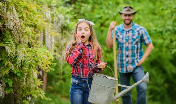 I love flowers. ecology. Watering can and shovel. little girl and happy man dad. earth day. spring village country. family farm. father and daughter on ranch. Living a green life - Foto, Bild