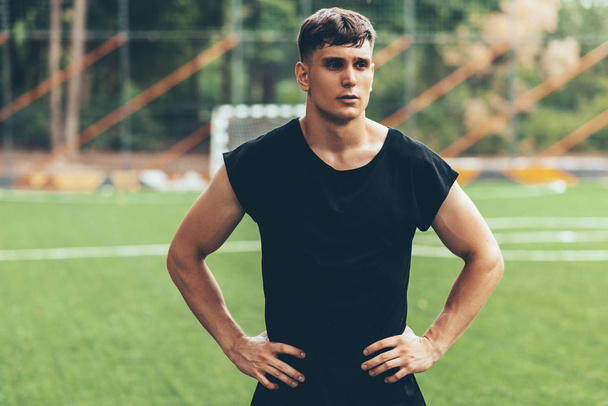 Portrait of healthy young man standing outdoors in the park and looking away, with hands on the waist, preparing for workout training. Confident young fitness man ready of workout. People and sport. - Fotoğraf, Görsel