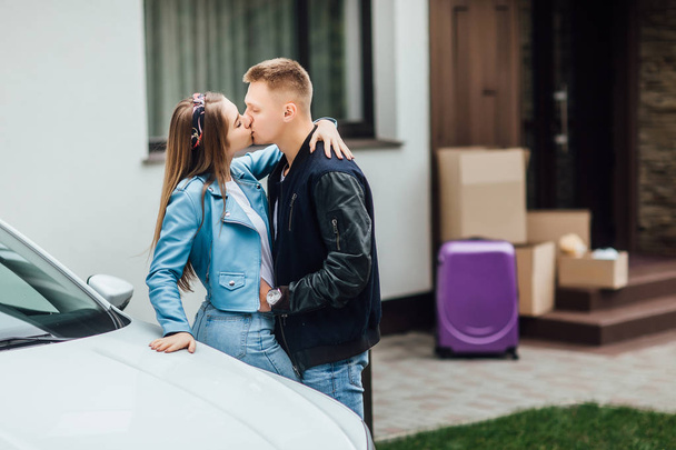 Attractive couple hugging near new white car and home - Fotografie, Obrázek
