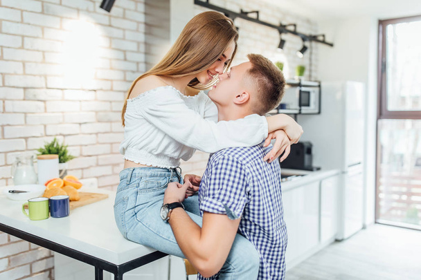 Happy loving couple hugging at kitchen, focus on foreground - Fotografie, Obrázek