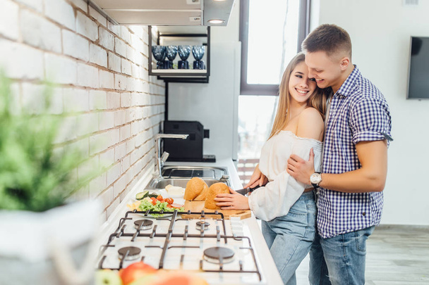 Happy and cheerful young couple at kitchen, focus on foreground - Фото, зображення