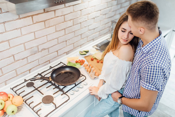 couple preparing breakfast at kitchen, focus on foreground - Foto, afbeelding