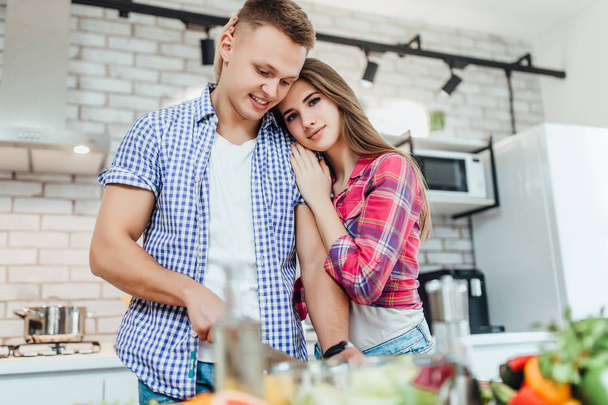 happy young couple preparing food at kitchen together - Foto, Bild