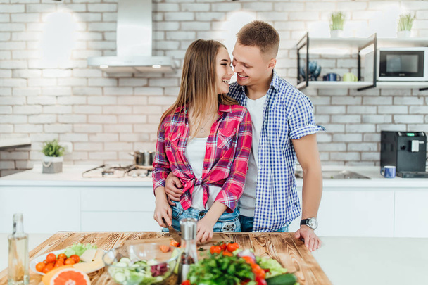 Young beautiful couple cooking at kitchen, selective focus - Foto, Bild