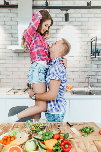 Romantic young couple cooking together at kitchen and having fun - Valokuva, kuva