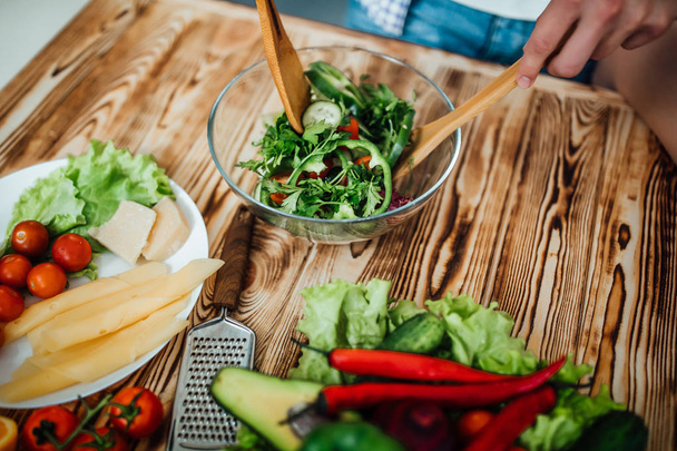 Ahşap masada salata yapan ellerin yakın çekim - Fotoğraf, Görsel