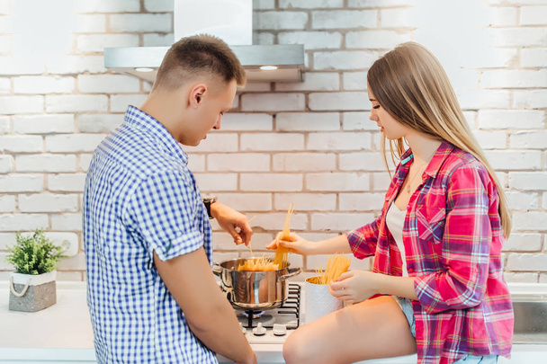 young positive couple preparing food together, focus on foreground - Fotoğraf, Görsel