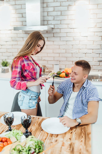 young positive couple preparing food together, focus on foreground - Foto, imagen