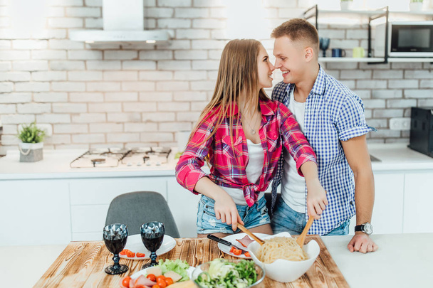 young positive couple preparing food together, focus on foreground - Foto, Imagem