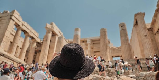 mulher ou menina com chapéu que olha a entrada principal do acropolis com turistas em Atenas em um dia ensolarado em Greece - destino da viagem
 - Foto, Imagem