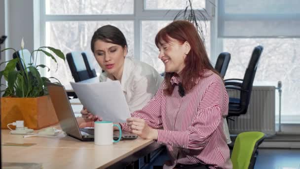Twee ondernemers doen samen papierwerk op kantoor - Video