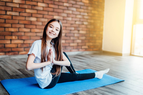 young girl practicing yoga at home, focus on foreground - 写真・画像