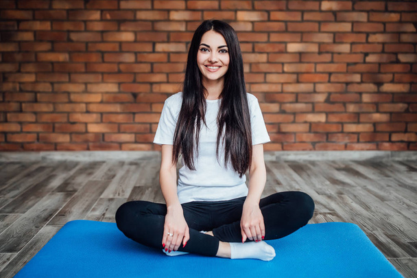 brunette woman practicing yoga at home, focus on foreground - Фото, зображення