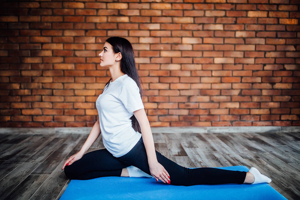 brunette woman practicing yoga at home, focus on foreground - Fotografie, Obrázek