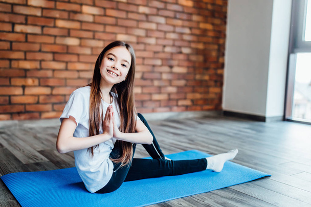 young girl practicing yoga at home, focus on foreground - 写真・画像