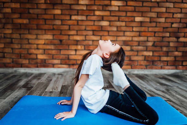 young girl practicing yoga at home, focus on foreground - Foto, Imagen