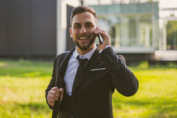 Elegant businessman using phone outdoor.Toned photo. - Foto, Imagen