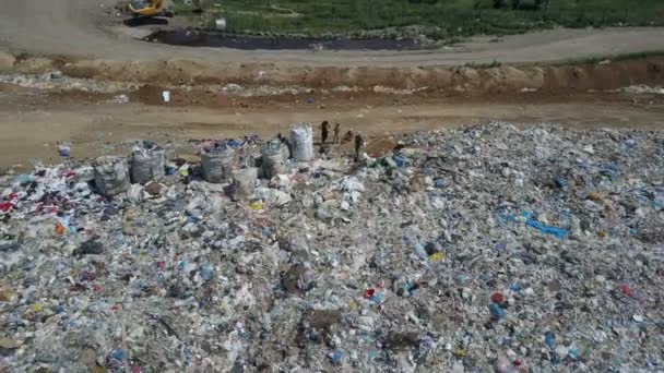 Aerial view of City garbage Dump. Gypsy family with children separates trash to gain some money - Footage, Video