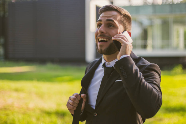 Elegant businessman using phone outdoor.Toned photo. - Foto, immagini
