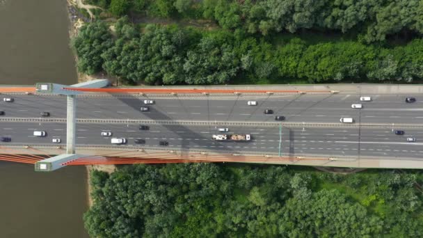 City auto rijdt met de brug van de snelweg op achtergrond glad rivierzicht oppervlakte drone - Video