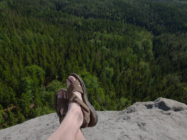 Çıplak kıllı erkek bacaklar ile deri sandalet dinlenme süre Trail.  - Fotoğraf, Görsel