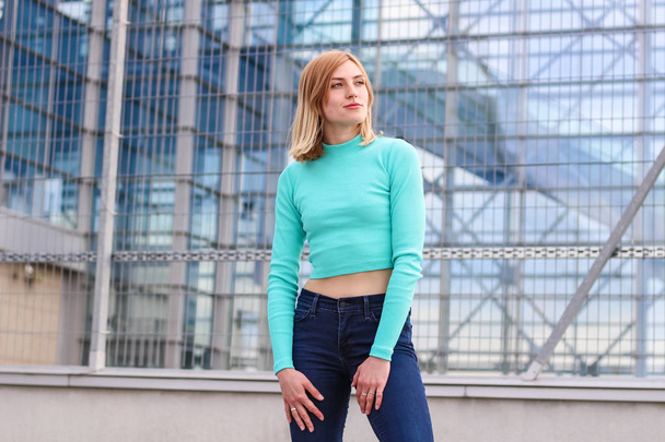 The girl is blonde in a blue croptop. Street clothing. Sport. Ad - Photo, Image