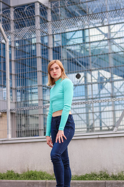 The girl is blonde in a blue croptop. Street clothing. Sport. Ad - Fotografie, Obrázek