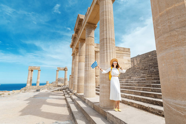 junge Reisende mit griechischer Flagge an den antiken griechischen Ruinen. Tourismus in Griechenland - Foto, Bild