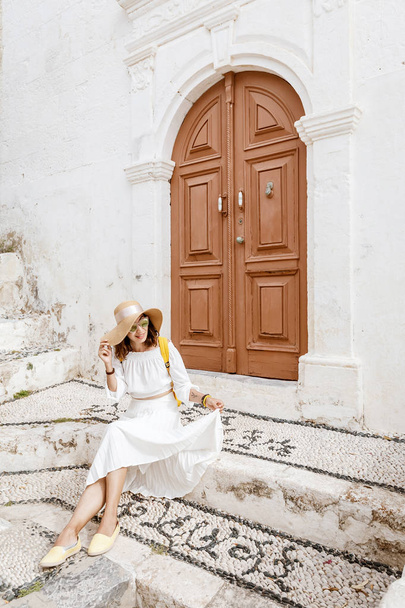eine junge Frau in der Nähe einer alten großen Holztür - Foto, Bild