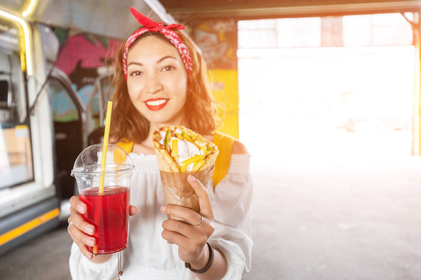 Asian dziewczyna degustacja tradycyjny grecki Fastfood Gyros Kebab w ulica kawiarnia. Kuchnia Śródziemnomorska i midlle Eastern - Zdjęcie, obraz