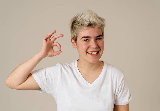 Young handsome teenager man showing ok gesture. Pretty cheerful transgender teen boy making ok sign looking happy and cheerful. In People, diversity, human rights and positive emotions concept. - Foto, afbeelding