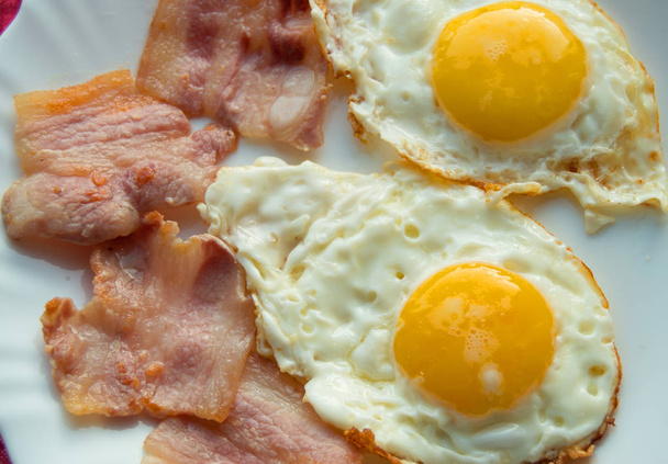 Heerlijk ontbijt - witte plaat gebakken eieren, bacon - Foto, afbeelding