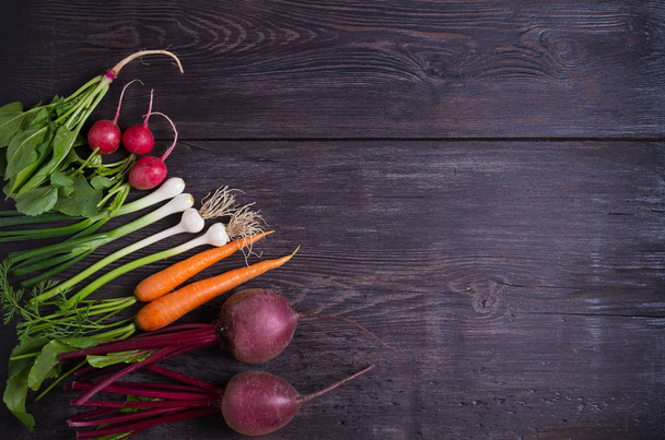 Carrots, beet, radishes, onions, garlic, spinach on wooden background. Flat lay, copy space - Image - Zdjęcie, obraz