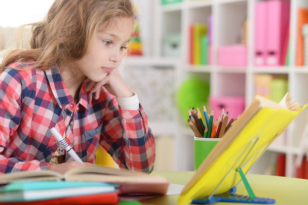 Мила дівчина-підліток робить домашнє завдання у своїй кімнаті
  - Фото, зображення