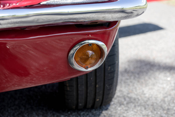 Zicht op een oranje richtings licht van een oude rode auto - Foto, afbeelding