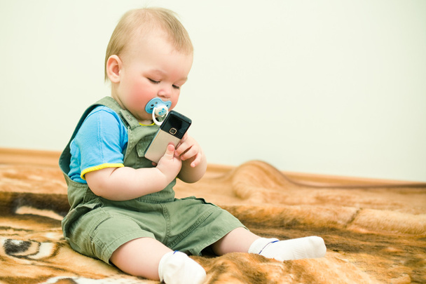 Baby looks at mobile phone with interest - Φωτογραφία, εικόνα