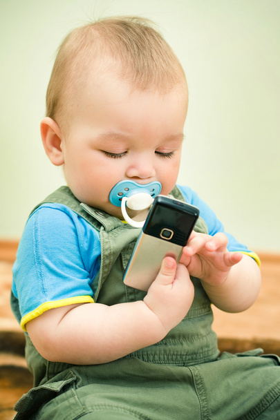 Baby playing with a cell phone - Zdjęcie, obraz