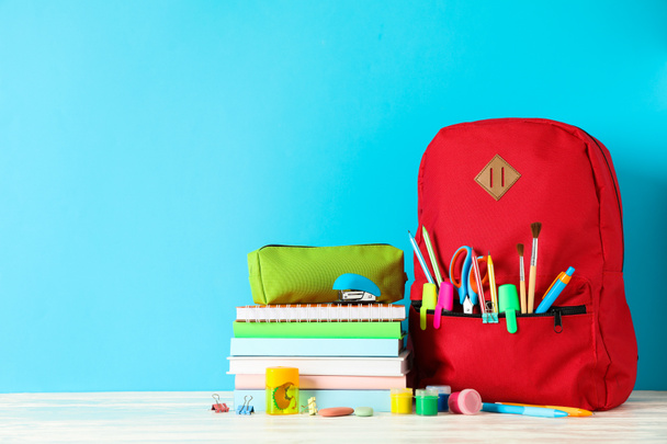Fournitures scolaires sur table en bois sur fond de couleur, espace
  - Photo, image